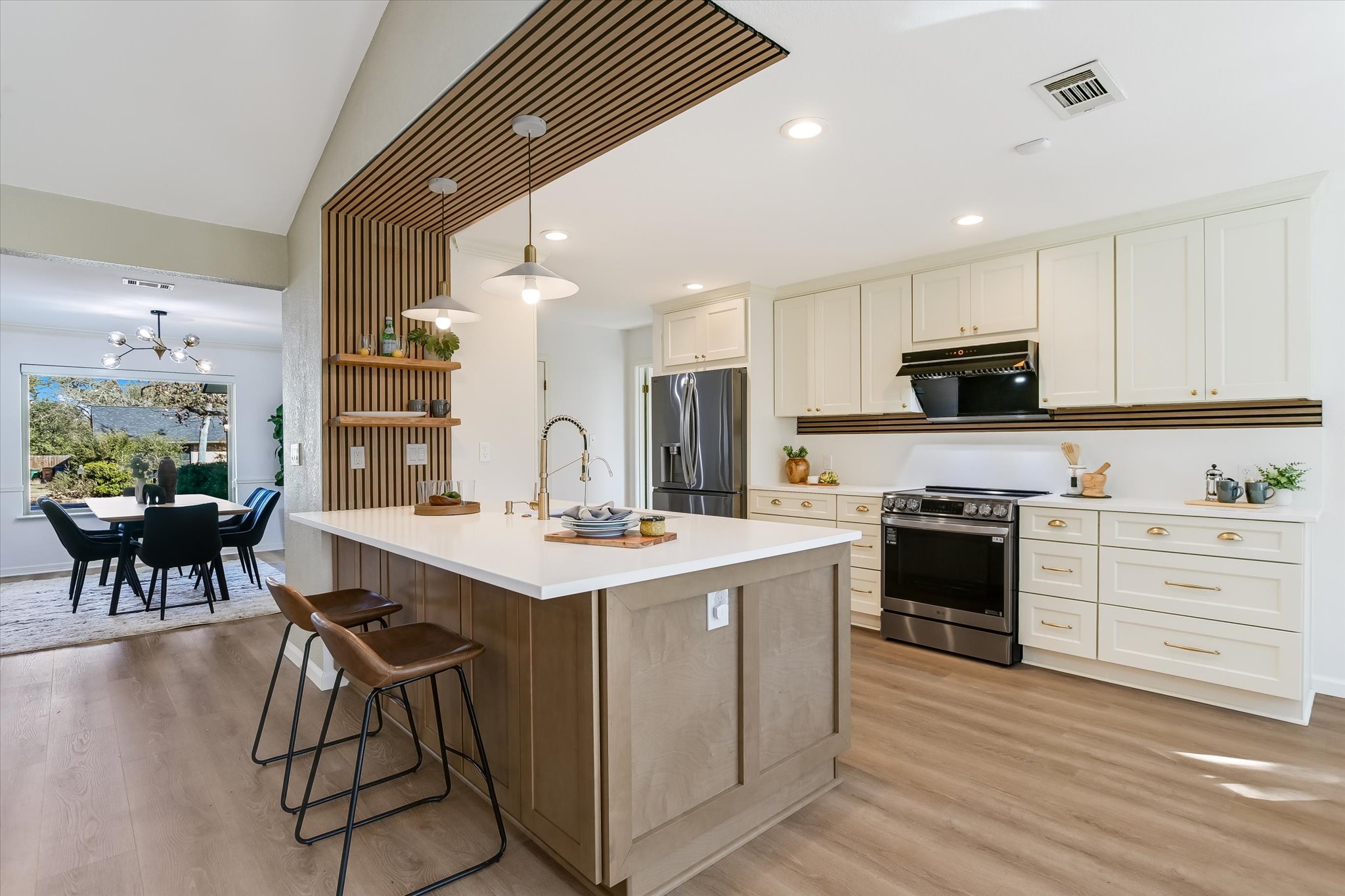 Kitchen with stainless steel appliances, a center island with sink, light wood-style floors, a breakfast bar, and recessed​​‌​​​​‌​​‌‌​‌‌​​‌​​​​‌​​​‌‌​‌‌‌ lighting