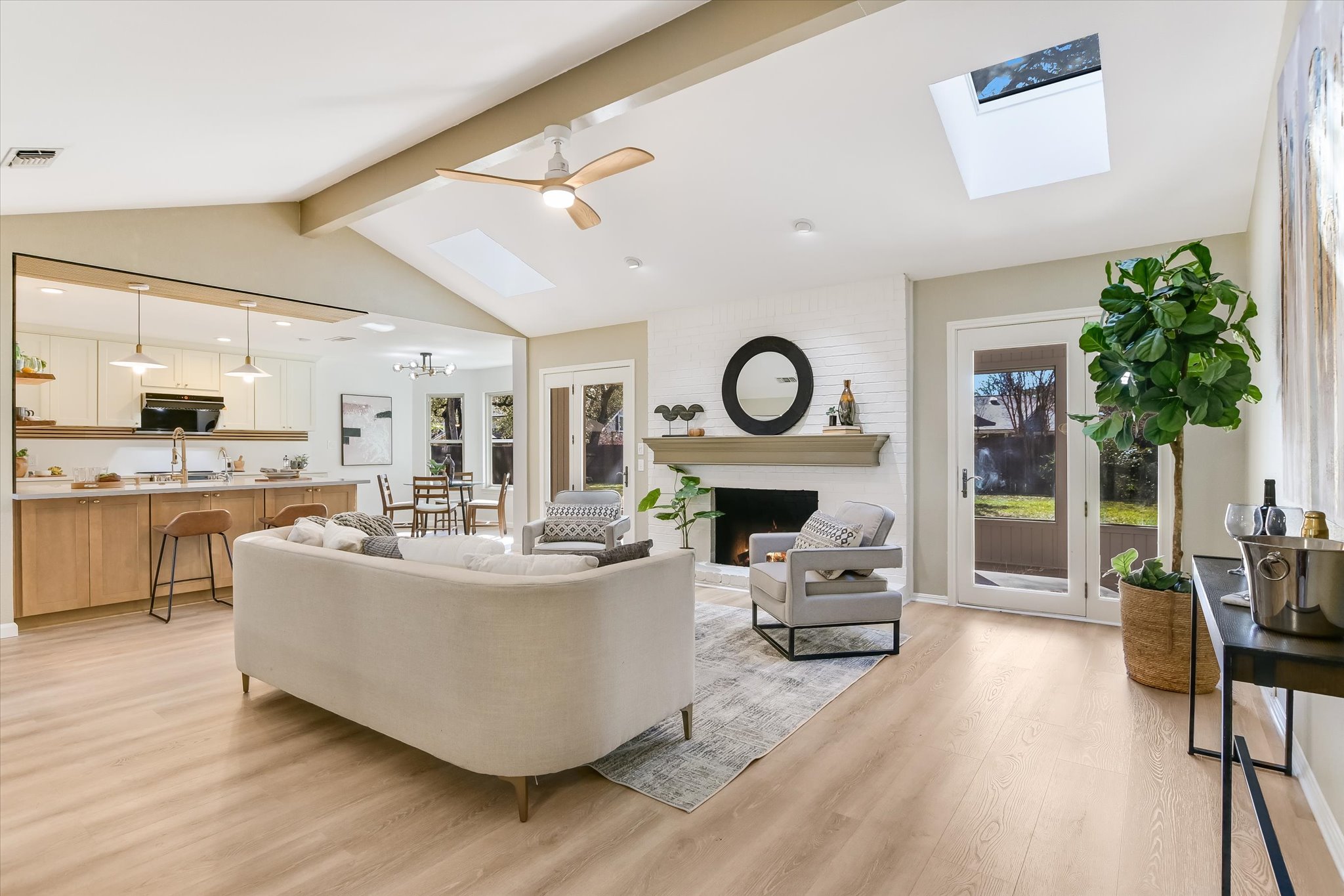 9905 Richelieu Road Austin, TX 78750 - Photo 2 of 32 Living area with light wood-style flooring, a skylight, a large fireplace, ceiling fan, and a chandelier