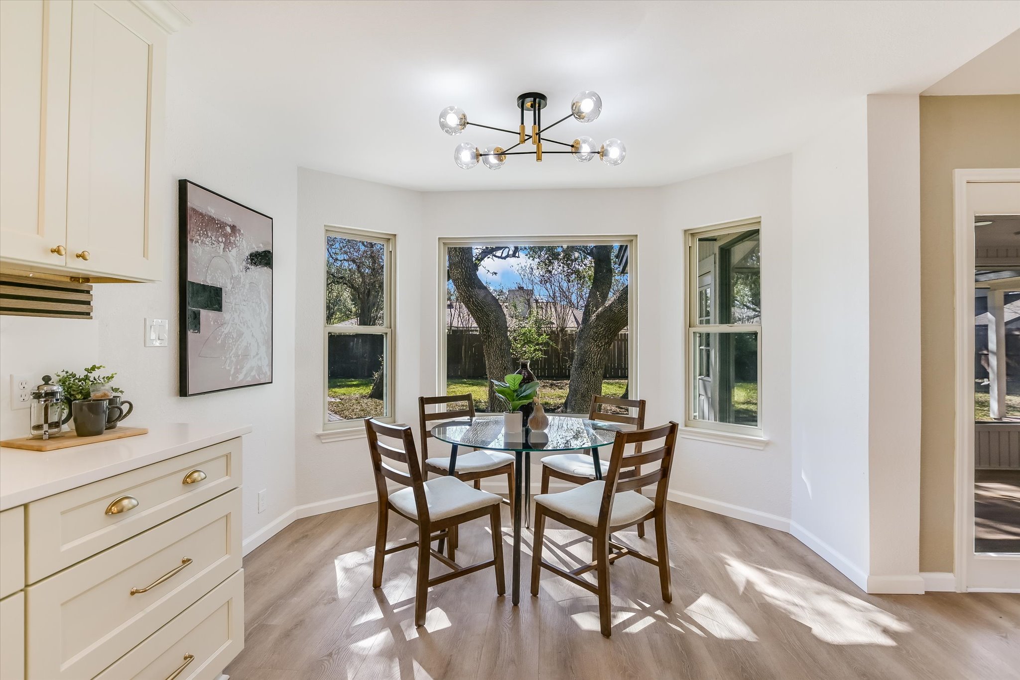 9905 Richelieu Road Austin, TX 78750 - Photo 4 of 32 Dining area featuring light wood style laminate flooring, plenty of natural light, and a chandelier