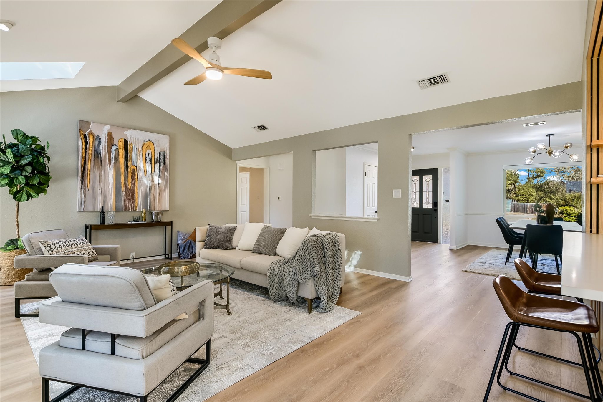 9905 Richelieu Road Austin, TX 78750 - Photo 5 of 32 Living area featuring a skylight, wood-style laminate floors, a chandelier, and a ceiling fan