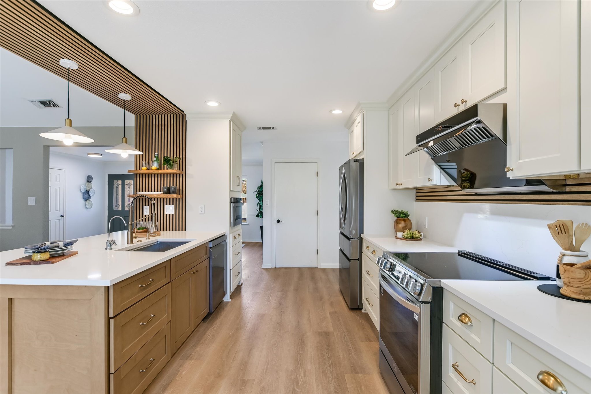 9905 Richelieu Road Austin, TX 78750 - Photo 8 of 32 Kitchen with stainless steel appliances, hanging light fixtures, white cabinetry, light wood look flooring, and recessed lighting