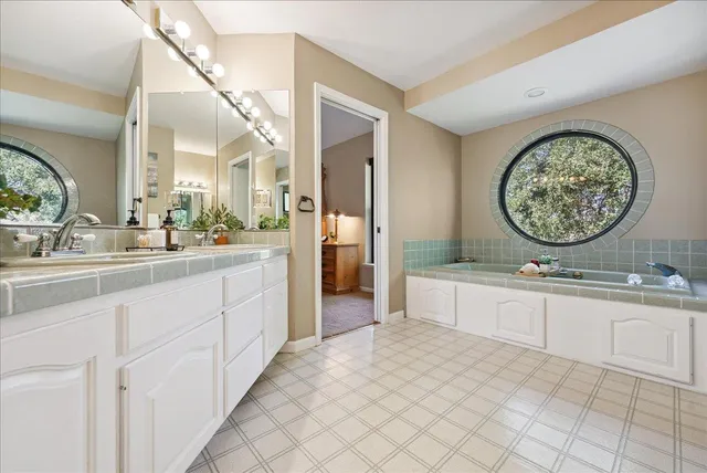 a spacious bedroom with a bed and a flat tv screen on wall