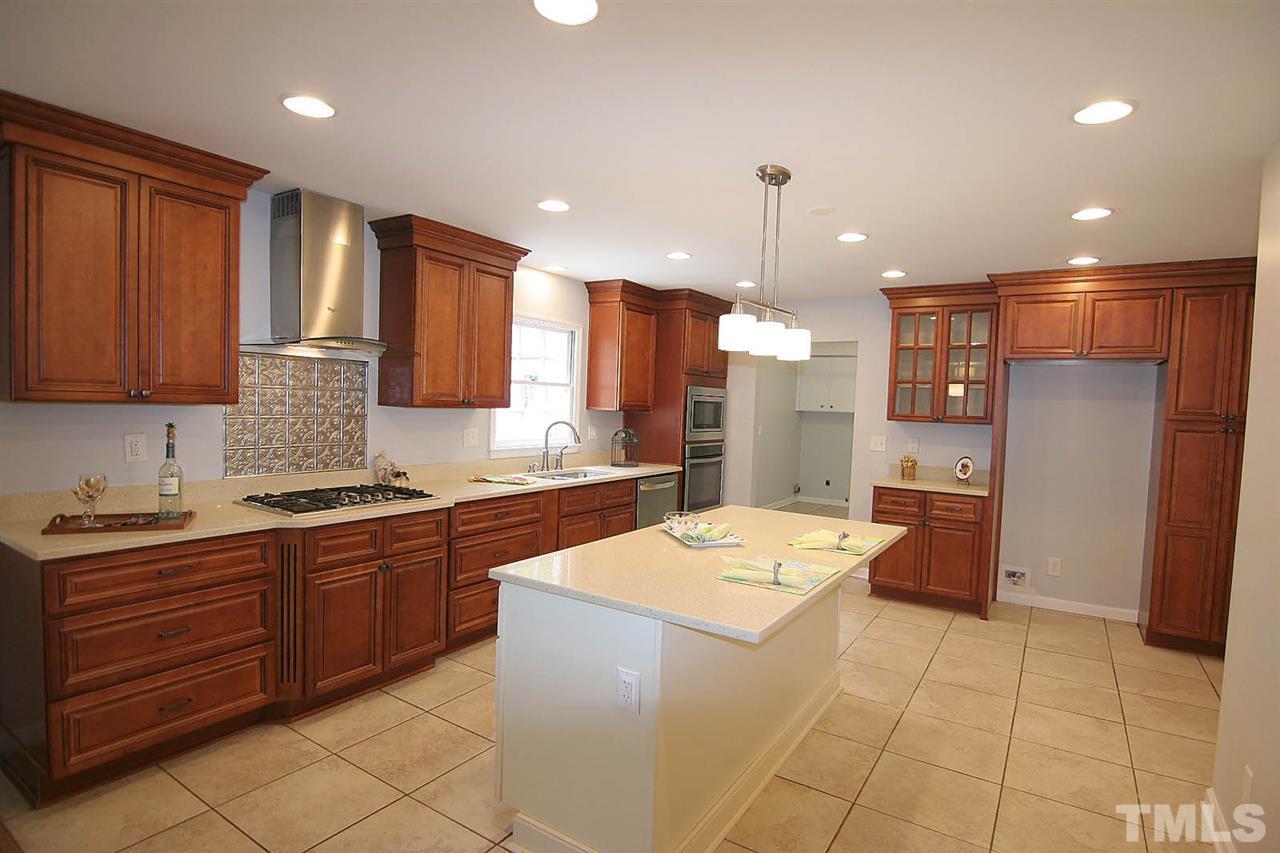 7801 Audubon Drive Raleigh, NC 27615 - Photo 11 of 25 a large kitchen with kitchen island a sink stainless steel appliances and cabinets