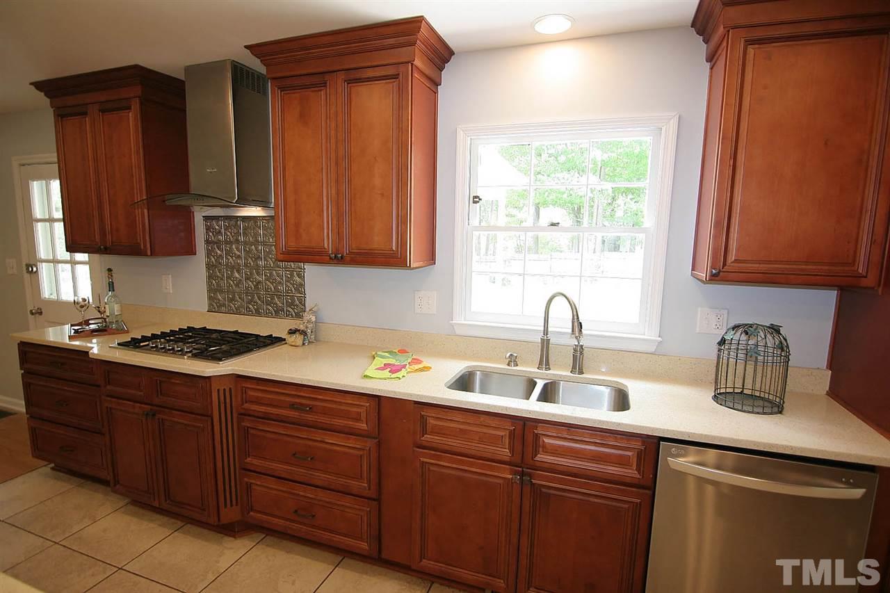 7801 Audubon Drive Raleigh, NC 27615 - Photo 12 of 25 a kitchen with stainless steel appliances granite countertop a sink stove and cabinets