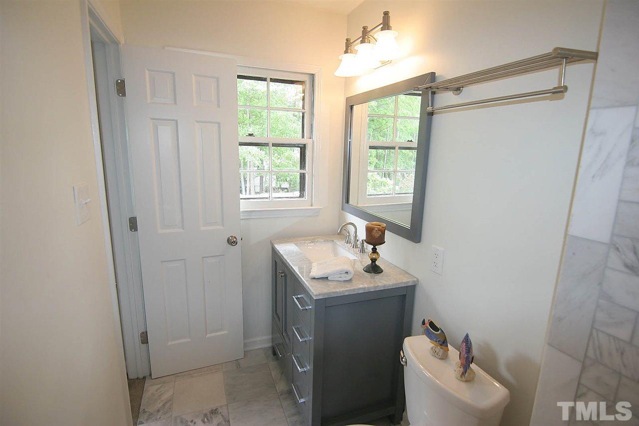 7801 Audubon Drive Raleigh, NC 27615 - Photo 18 of 25 a bathroom with a sink toilet and window
