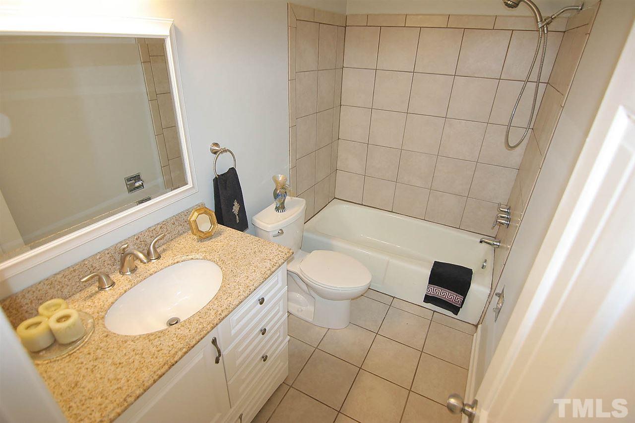 7801 Audubon Drive Raleigh, NC 27615 - Photo 21 of 25 a bathroom with a granite countertop sink and a mirror