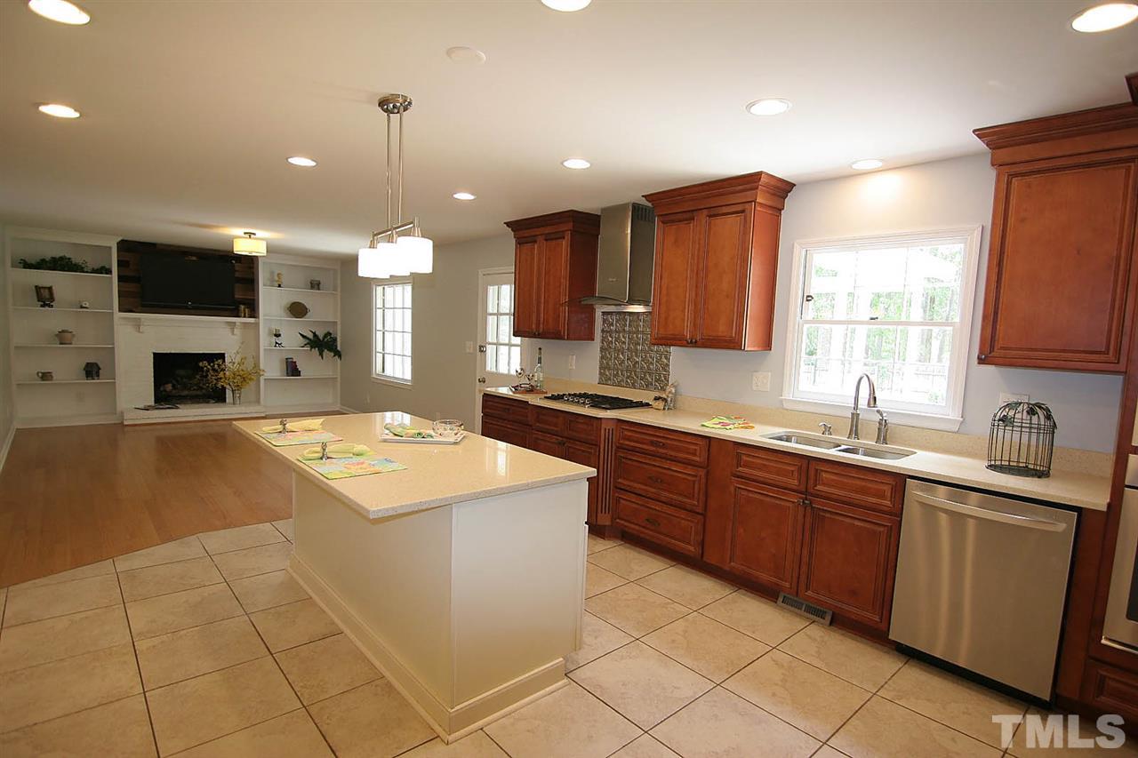 7801 Audubon Drive Raleigh, NC 27615 - Photo 8 of 25 a large kitchen with stainless steel appliances granite countertop a sink and a stove top oven