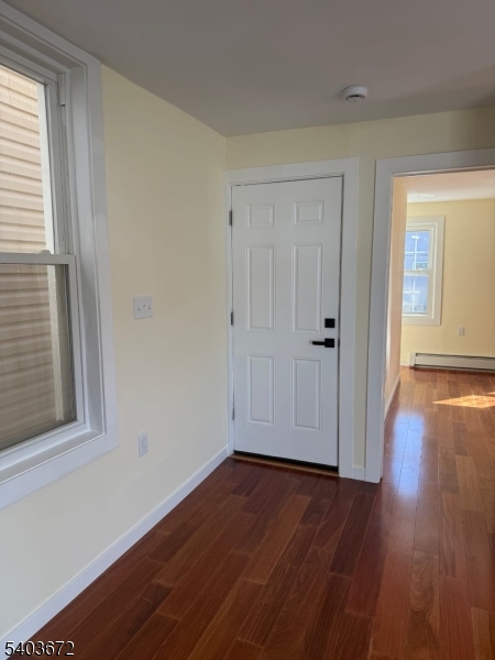 863 Lafayette Street Elizabeth, NJ 07201 - Photo 13 of 20 an empty room with wooden floor and windows