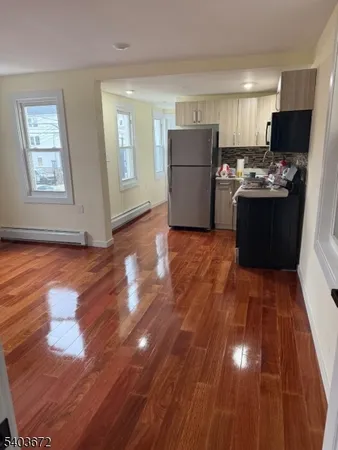 a kitchen with wooden floors and refrigerator