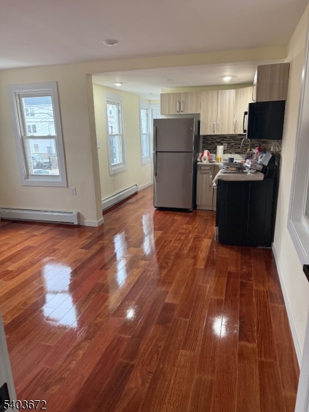 863 Lafayette Street Elizabeth, NJ 07201 - Photo 7 of 20 a kitchen with wooden floors and refrigerator