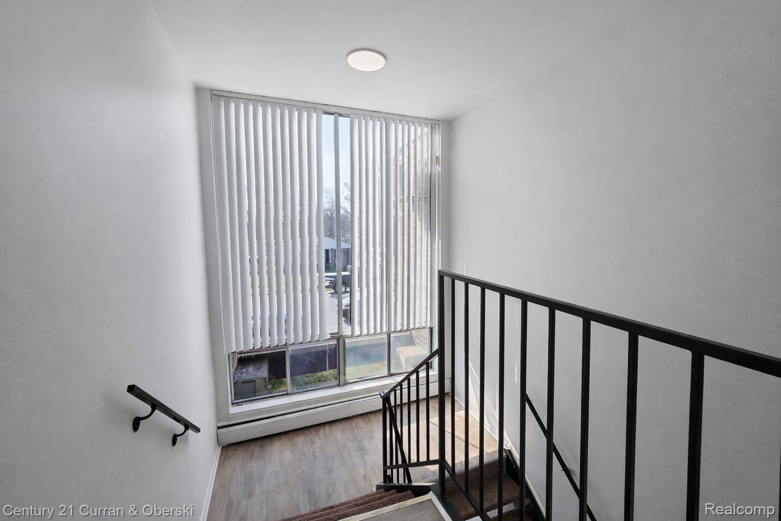 6015 Southfield Road, Unit 6 Detroit, MI 48228 - Photo 4 of 10 Stairs with a baseboard heating unit and wood finished floors