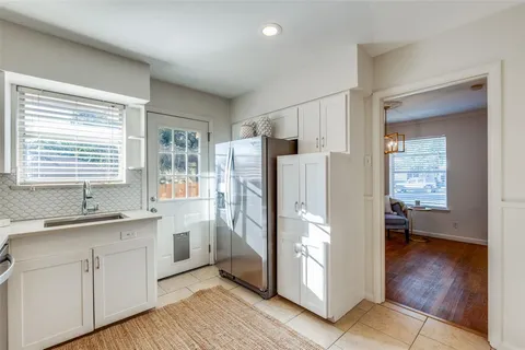 a kitchen with a refrigerator a sink and wooden floor