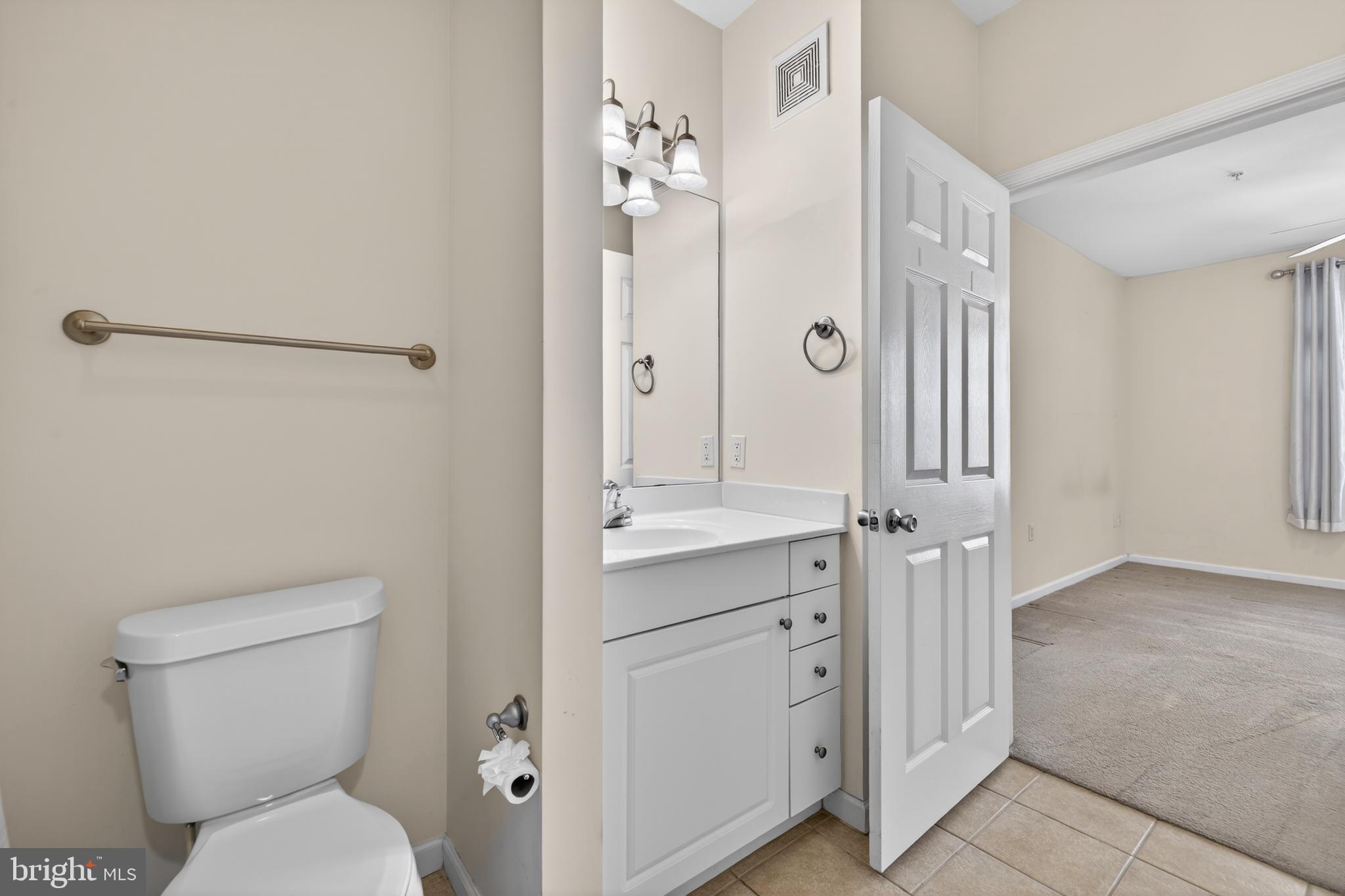 31 Booth Street, Unit 358 Gaithersburg, MD 20878 - Photo 16 of 20 a bathroom with a granite countertop toilet a sink and a mirror