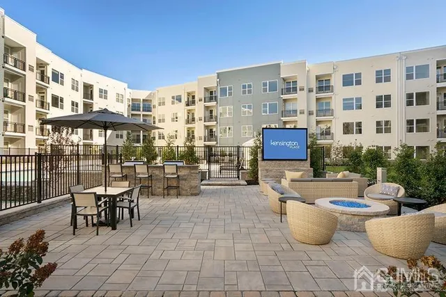 a view of a patio with couple of chairs and potted plants