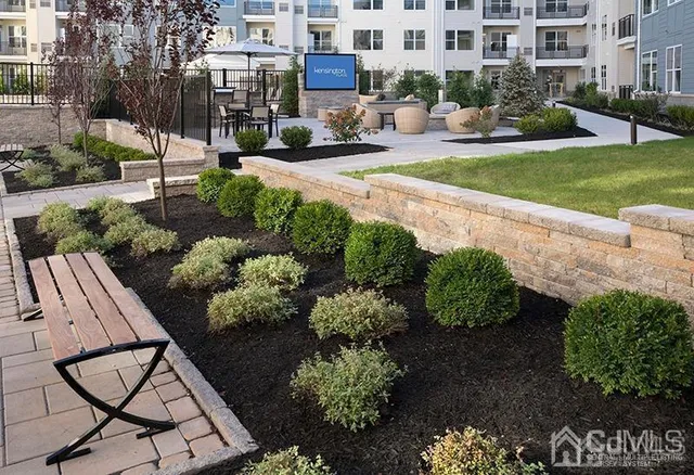 a front view of a building with a garden and plants