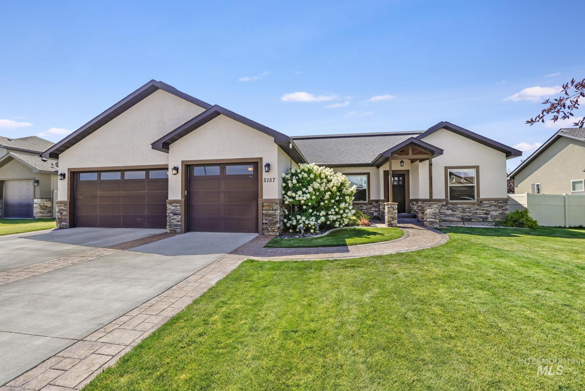 2157 Cayuse Street Twin Falls, ID 83301 - Photo 1 of 48 View of front of home with stone siding, stucco siding, an attached garage, and concrete driveway