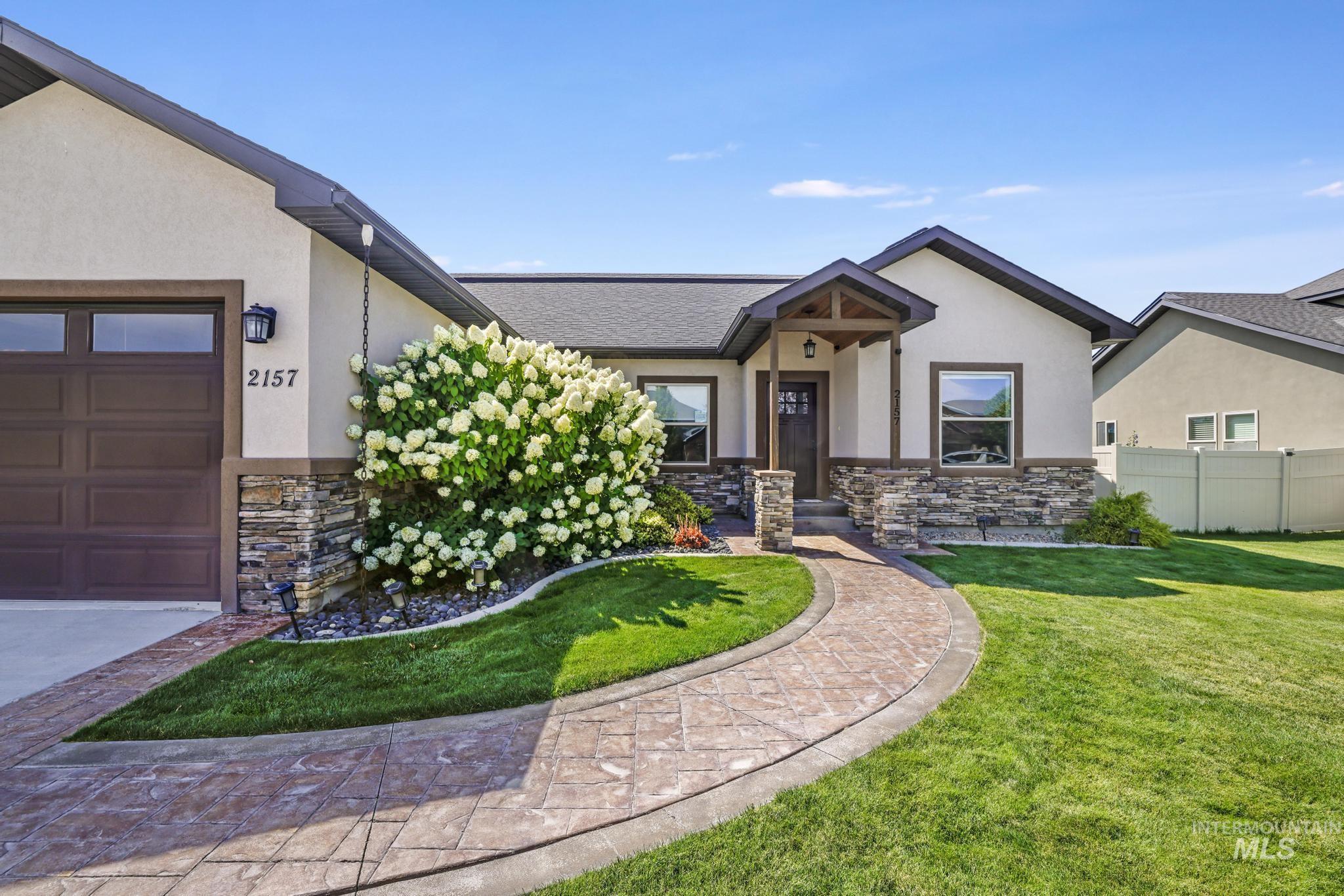 2157 Cayuse Street Twin Falls, ID 83301 - Photo 2 of 48 View of front of home with stone siding, an attached garage, and stucco siding