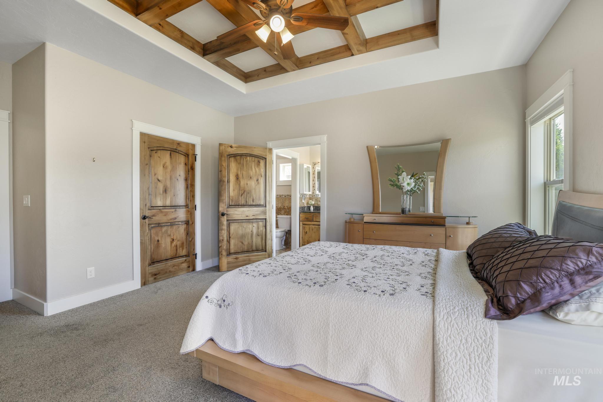 2157 Cayuse Street Twin Falls, ID 83301 - Photo 24 of 48 Carpeted bedroom featuring coffered ceiling, beamed ceiling, multiple windows, ceiling fan, and ensuite bath