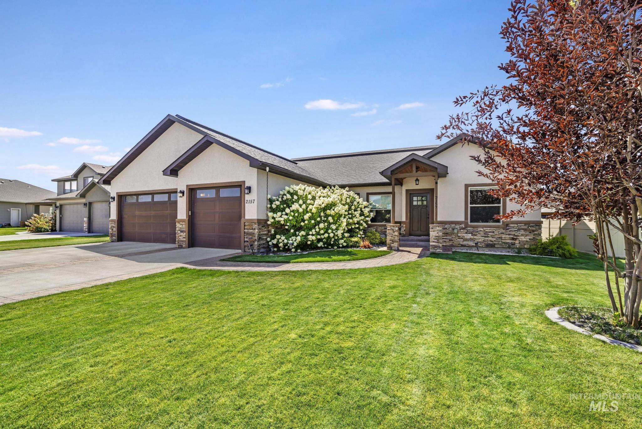2157 Cayuse Street Twin Falls, ID 83301 - Photo 3 of 48 View of front facade with stone siding, an attached garage, stucco siding, a front yard, and concrete driveway
