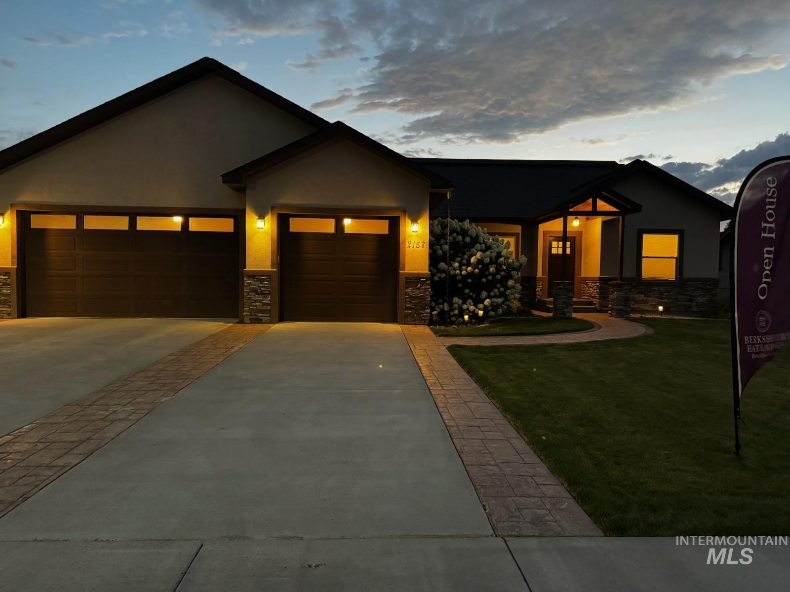 2157 Cayuse Street Twin Falls, ID 83301 - Photo 4 of 48 View of front facade with a garage, stone siding, stucco siding, concrete driveway, and a front lawn