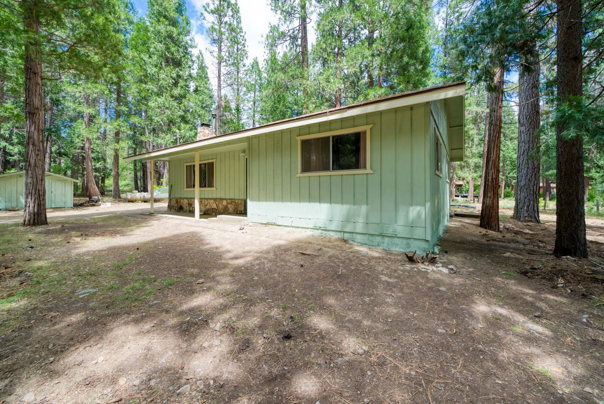 58374 Gill Ranch Road Cromberg, CA 96103 - Photo 9 of 44 a view of a backyard with large trees and a small barn