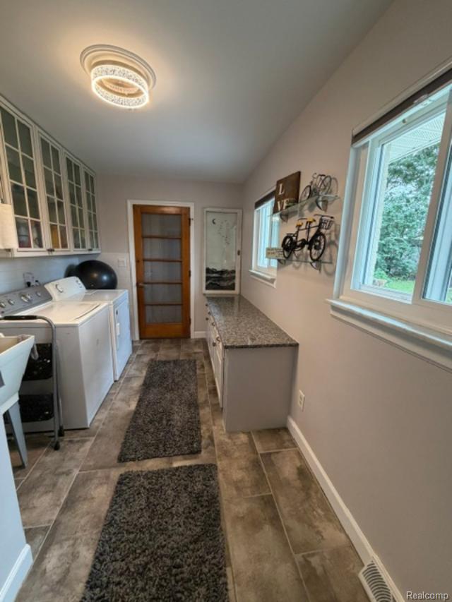 1615 Ladd Road Walled Lake, MI 48390 - Photo 25 of 28 Tile flooring, white window frames, wood-finish interior door, flush-mount lighting, and lower cabinetry with a stone-finish countertop