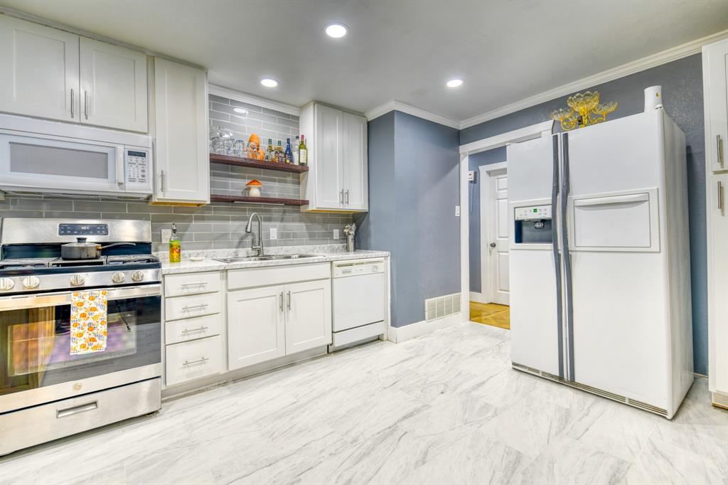 3214 Parker Street Irving, TX 75062 - Photo 12 of 22 a kitchen with white cabinets and stainless steel appliances