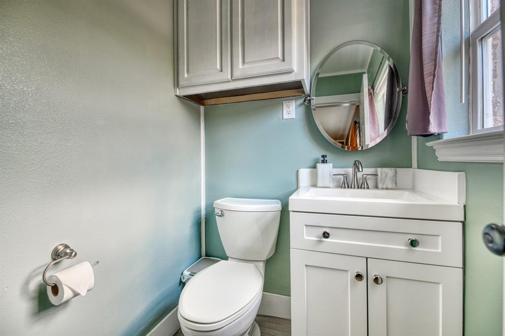 3214 Parker Street Irving, TX 75062 - Photo 15 of 22 a bathroom with a toilet sink and mirror