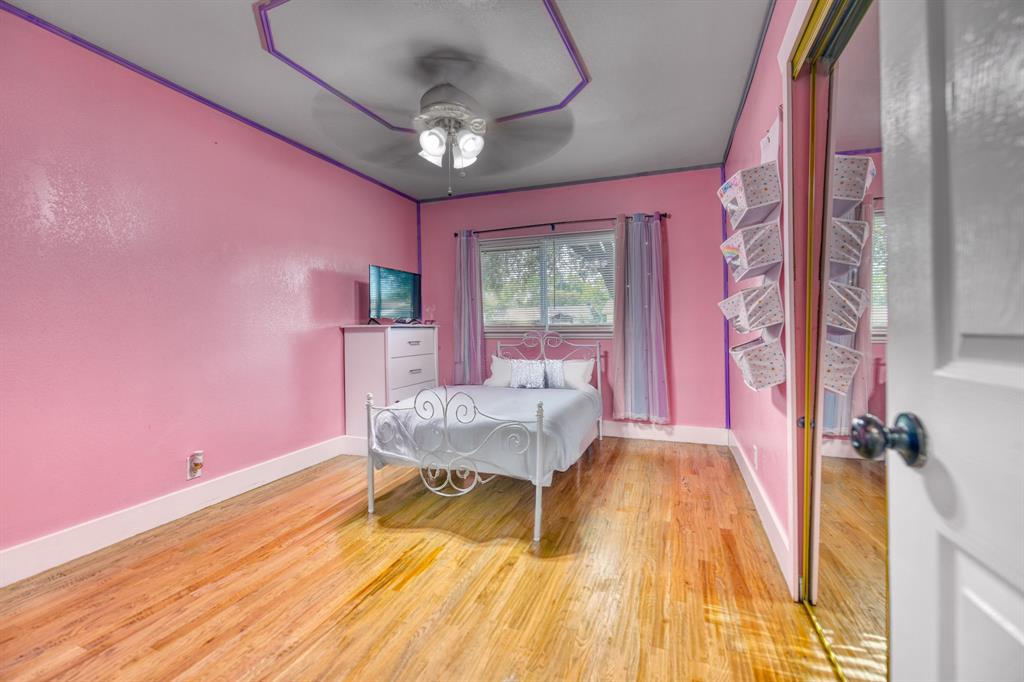 3214 Parker Street Irving, TX 75062 - Photo 18 of 22 a bed room with a bed and a chandelier