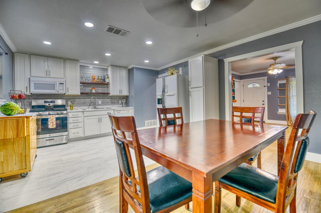 3214 Parker Street Irving, TX 75062 - Photo 8 of 22 a kitchen with stainless steel appliances granite countertop a stove a refrigerator a kitchen island a table and chairs