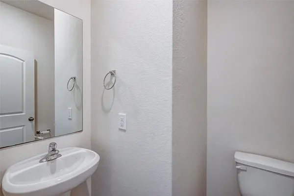 a bathroom with a sink a toilet and a mirror