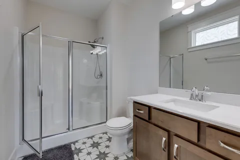 a bathroom with a sink toilet a mirror and shower
