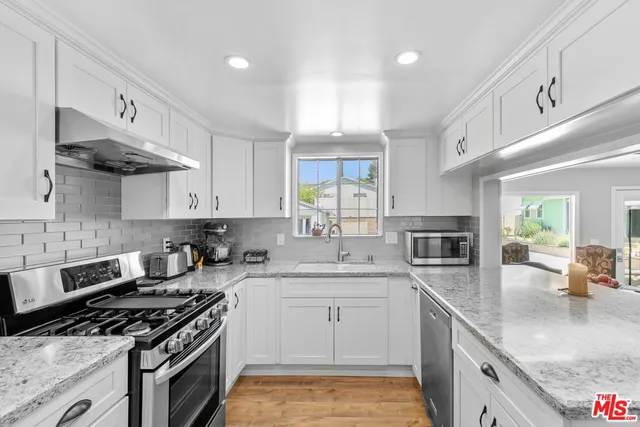 a kitchen with stainless steel appliances a sink stove and cabinets