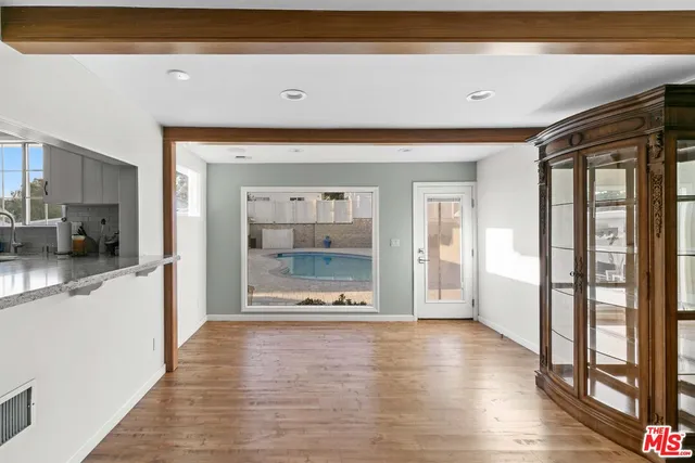a view of a hallway with wooden floor and a living room