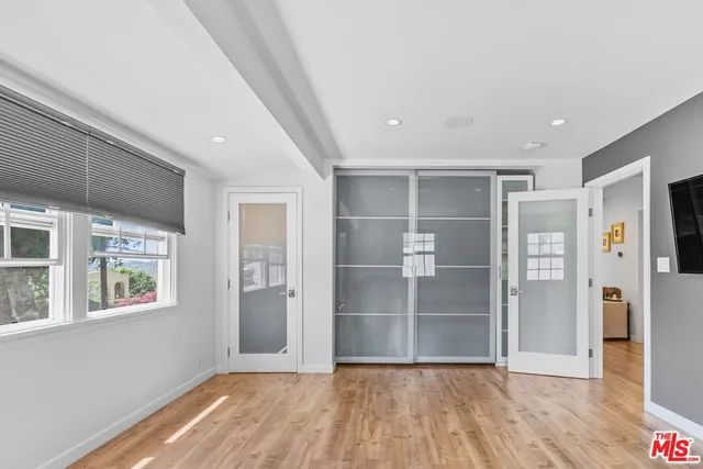 a view of empty room with wooden floor and window