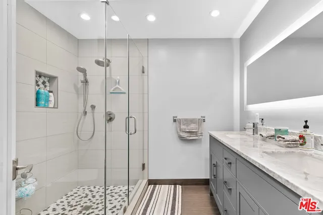 a bathroom with a shower sink and mirror