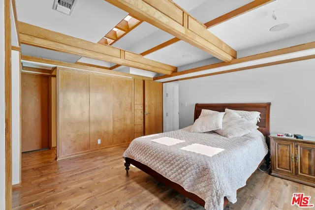 a bedroom with a bed and a large mirror