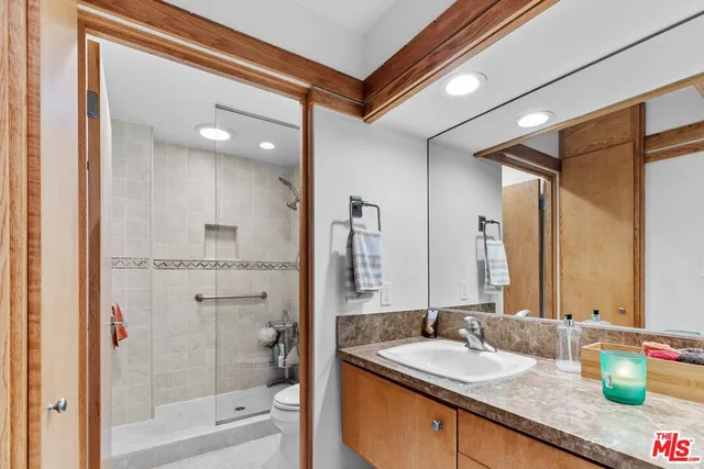 a bathroom with a granite countertop sink a mirror and a bathtub