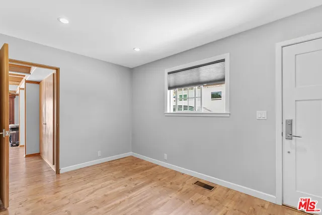 an empty room with wooden floor and a window