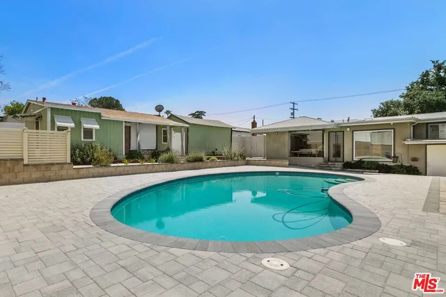 a view of a house with a swimming pool and a yard