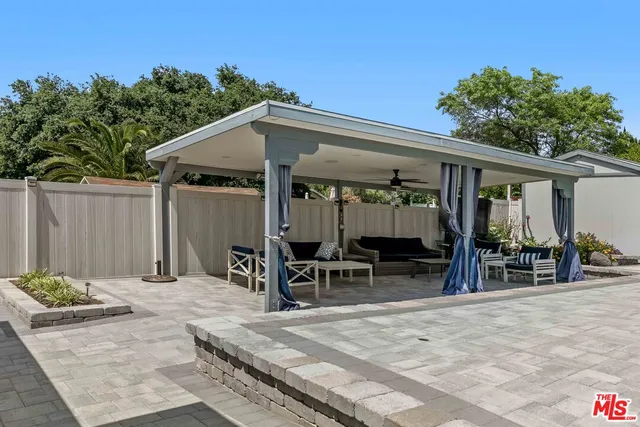 a patio with table and chairs and potted plants