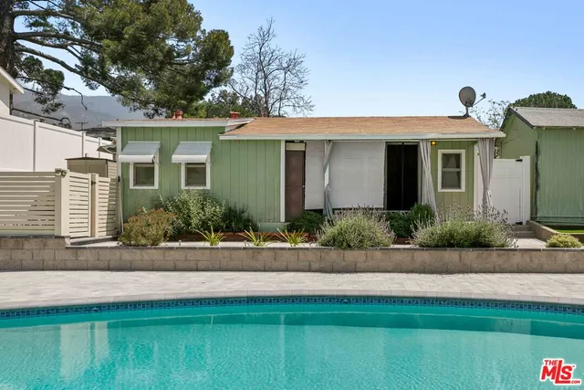 a front view of a house with garage and plants