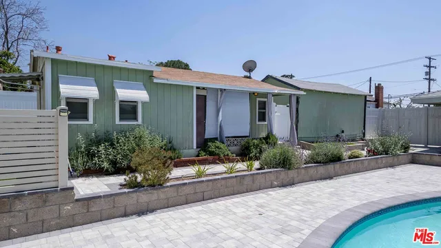 a front view of a house with garage and plants