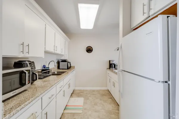 a kitchen with granite countertop a sink stove and refrigerator