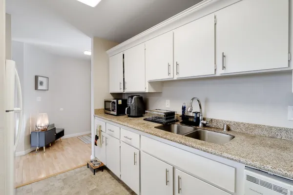 a kitchen with stainless steel appliances granite countertop white cabinets sink and dishwasher
