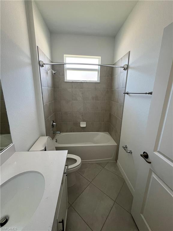 2320 Dragonfruit Way Naples, FL 34120 - Photo 13 of 33 Full bath with washtub / shower combination, tile patterned floors, vanity, and toilet