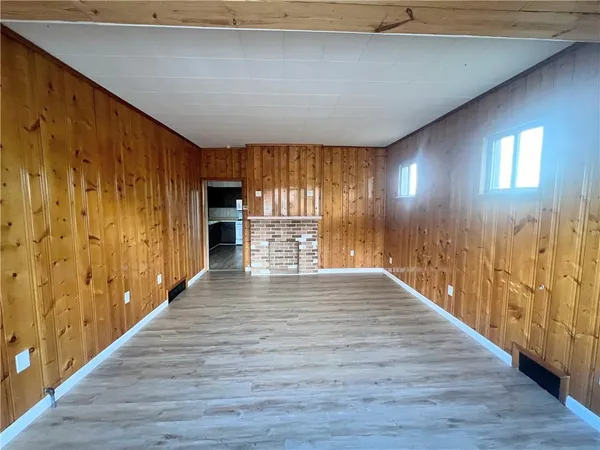 a view of a hallway with wooden floor and a fireplace