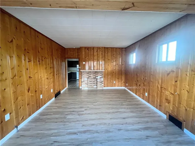 a view of a hallway with wooden floor and a fireplace