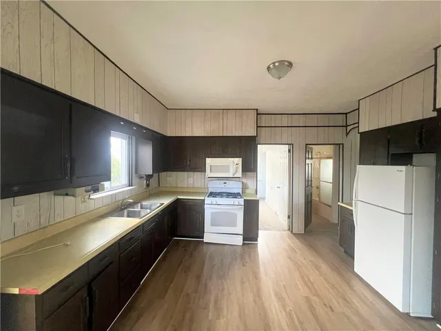 a large kitchen with a wooden floor and stainless steel appliances