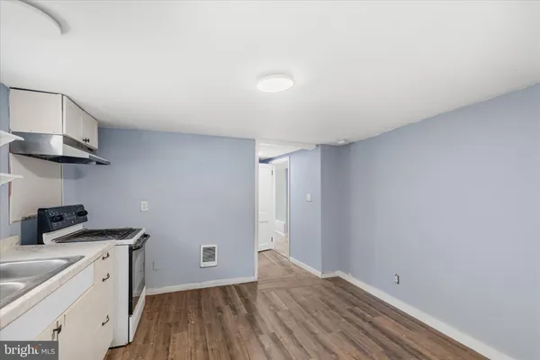 a view of a kitchen with a sink wooden floor and cabinets